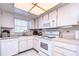 White corner kitchen with ample cabinetry and appliances at 5555 Gulf Blvd # 209, St Pete Beach, FL 33706