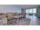 Light and airy living room featuring a comfortable seating area and a view to a balcony at 5555 Gulf Blvd # 209, St Pete Beach, FL 33706