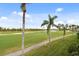 Expansive view of a green golf course, palm trees, and a walking path at 6181 Bahia Del Mar Blvd # 209, St Petersburg, FL 33715