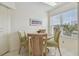 Bright dining area with round table and four green chairs at 6181 Bahia Del Mar Blvd # 209, St Petersburg, FL 33715