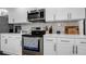 Modern kitchen with white cabinets, quartz countertops, and stainless steel appliances at 7209 N Highland Ave, Tampa, FL 33604