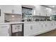 Modern white kitchen with marble backsplash and stainless steel appliances at 7209 N Highland Ave, Tampa, FL 33604