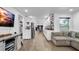 Open concept living area with hardwood floors, sectional sofa, and white kitchen cabinets at 7209 N Highland Ave, Tampa, FL 33604