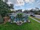 Quaint light blue home with a well-maintained lawn and tropical landscaping at 825 46Th N St, St Petersburg, FL 33713