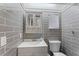 Up close shot of the bathroom, featuring stylish gray tile and a medicine cabinet above the sink at 1033 Jamaica Way, Tarpon Springs, FL 34689