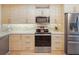 Modern kitchen with stainless steel appliances and light wood cabinets at 1111 N Bayshore Blvd # F6, Clearwater, FL 33759