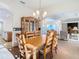Bright dining area with wooden table and hutch, adjacent to kitchen at 11620 Eastern Star Ct, New Port Richey, FL 34654
