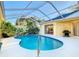 Relaxing kidney-shaped pool with a screened enclosure at 11620 Eastern Star Ct, New Port Richey, FL 34654