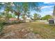 Backyard features mature trees, wooden fence, and partial view of neighboring properties at 1230 32Nd N St, St Petersburg, FL 33713
