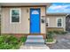 Inviting home exterior with a bright blue door and well-maintained landscaping at 1230 32Nd N St, St Petersburg, FL 33713