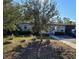 Tan one-story house with blue door, landscaping, and driveway at 1230 32Nd N St, St Petersburg, FL 33713
