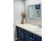 Bathroom with navy blue vanity, white countertop, and a large mirror at 1310 Hammock Pine Blvd, Clearwater, FL 33761