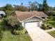 House with a two-car garage and landscaped yard at 1658 Macdonnell Ct, Palm Harbor, FL 34684