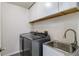 Laundry room with modern washer, dryer, and utility sink at 2250 Rio De Janeiro Ave, Punta Gorda, FL 33983