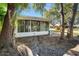 White sunroom nestled among lush trees, providing shade and privacy at 361 Estero Ct, Safety Harbor, FL 34695