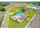 An aerial view of a large community pool and recreation facility with tennis courts and clubhouse at 36401 Camp Fire Ter, Zephyrhills, FL 33541