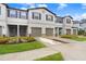 Three-unit townhouse building with gray siding, purple shutters, and attached garages at 36401 Camp Fire Ter, Zephyrhills, FL 33541
