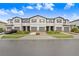Townhouse exterior featuring three-car garages and well-manicured landscaping at 36401 Camp Fire Ter, Zephyrhills, FL 33541