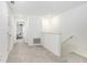 Upstairs hallway with carpeted floors and doors to bedrooms at 36401 Camp Fire Ter, Zephyrhills, FL 33541