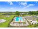 A gorgeous aerial view of the community pool and recreation facilities, including tennis courts, playground, and clubhouse at 36401 Camp Fire Ter, Zephyrhills, FL 33541