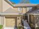 Tan two-story townhome with attached garage and walkway at 4207 Key Thatch Dr, Tampa, FL 33610
