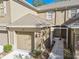 Tan two-story townhome with attached garage and walkway at 4207 Key Thatch Dr, Tampa, FL 33610