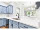 Modern kitchen with blue cabinets, black appliances, and white countertops at 4207 Key Thatch Dr, Tampa, FL 33610