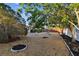 Landscaped backyard with gravel, trees, and a picnic table at 4235 Moody St, St Pete Beach, FL 33706