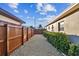 Side yard with gravel pathway, wooden fence, and lush hedges at 4235 Moody St, St Pete Beach, FL 33706