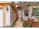 Front entrance with a screen door, brick pathway, and lush landscaping at 4936 Sandy Brook Cir, Wimauma, FL 33598