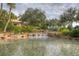 Serene pond with waterfall and lush tropical landscaping at 4936 Sandy Brook Cir, Wimauma, FL 33598