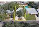 Aerial view of the property showing the house, yard, driveway, mature trees and nearby swimming pool at 51 Lexington Dr, Dunedin, FL 34698
