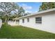 Side yard with sliding glass doors and lush green grass at 51 Lexington Dr, Dunedin, FL 34698