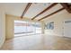 Open living room featuring exposed wood beams, tile floors and a glass sliding door at 51 Lexington Dr, Dunedin, FL 34698