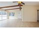 Bright living room featuring a ceiling fan, exposed beams, and a front door at 51 Lexington Dr, Dunedin, FL 34698