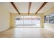 Bright living room featuring exposed wood beams, tile floors, and sliding glass doors to the outdoor area at 51 Lexington Dr, Dunedin, FL 34698