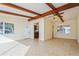 Living room featuring exposed beams and a partial view of the kitchen at 51 Lexington Dr, Dunedin, FL 34698