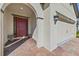 Inviting home exterior featuring a red front door, an arched entryway, and a well-maintained two-car garage at 6032 Milestone Dr, Apollo Beach, FL 33572