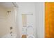 Functional bathroom with a bathtub-shower combo, toilet, and wooden door at 6543 Barcelona Blvd, Brooksville, FL 34602