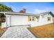 Beautiful single-story home featuring a white exterior, a light-colored roof, and a modern driveway at 6543 Barcelona Blvd, Brooksville, FL 34602