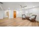 Bright living room with sleek wood floors, ceiling fan, two wicker chairs, and a side table at 6543 Barcelona Blvd, Brooksville, FL 34602