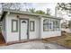 White stucco house with a green trim, sunroom, and nicely manicured lawn at 6699 78Th N Ave, Pinellas Park, FL 33781