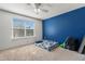 Bedroom with blue accent wall and large window at 6944 Towne Lake Rd, Riverview, FL 33578