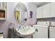Small bathroom with pedestal sink, toilet and laundry area at 718 40Th Ne Ave, St Petersburg, FL 33703