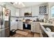 Updated kitchen, featuring gray cabinets, stainless steel appliances, and mosaic backsplash at 718 40Th Ne Ave, St Petersburg, FL 33703