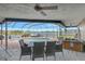 Covered patio with outdoor dining and lake view at 7643 Vienna Ln, Port Richey, FL 34668