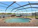 Screened-in pool with lake view and patio furniture at 7643 Vienna Ln, Port Richey, FL 34668