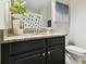 Bathroom with granite countertop, dark brown vanity, and toilet at 10374 Echo Dock Loop, San Antonio, FL 33576