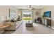 Comfortable living room with a beige sofa, green curtains, and sliding glass doors leading to the backyard at 10558 Dusty Boot Rd, Land O Lakes, FL 34638