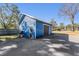 Detached blue garage with a dark brown door at 14045 21St St, Dade City, FL 33525